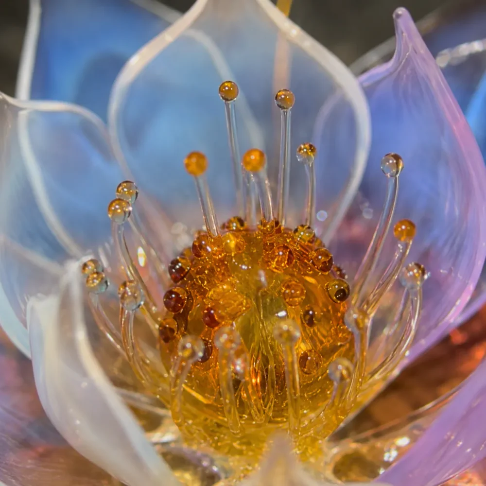 Aurora Lotus amber glass center with delicate glass stamen and soft blue-white lavender petals