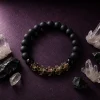Spiritual advertising poster of 9Purple obsidian bracelet surrounding raw natural clear quartz crystal clusters and black meteorite fragments.