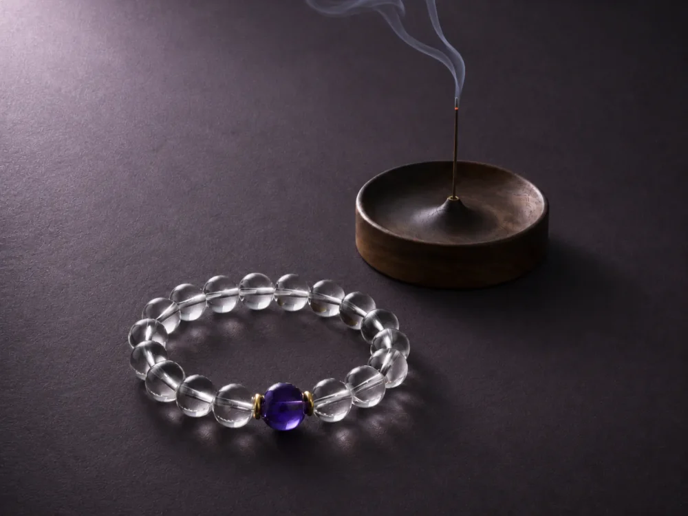 Water Flow bracelet with clear quartz beads, purple amethyst center bead, gold-plated spacers, and incense tray