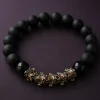 9Purple minimalist luxury dark zen beaded bracelet featuring matte and high-gloss black obsidian beads with vintage metal beast charms on a deep plum stone background.