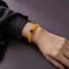 Earth Ground Yellow Agate Amethyst Bracelet Female Wrist Shot Earth Ground bracelet worn on female wrist with yellow agate beads, purple amethyst center bead, and gold-plated spacers