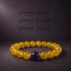 Earth Ground Yellow Agate Amethyst Bracelet Hero Image Earth Ground bracelet with yellow agate beads, purple amethyst center bead, and gold-plated spacers on dark textured background