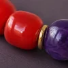Fire Radiance bracelet macro detail with Nanhong agate beads, purple amethyst center bead, and gold-plated spacers