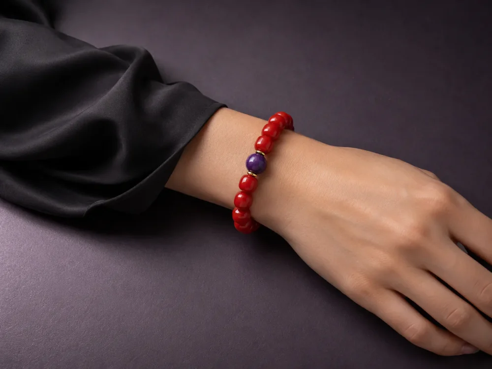 Fire Radiance bracelet worn on female wrist with Nanhong agate beads, purple amethyst center bead, and gold-plated spacers