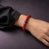 Fire Radiance bracelet worn on female wrist with Nanhong agate beads, purple amethyst center bead, and gold-plated spacers