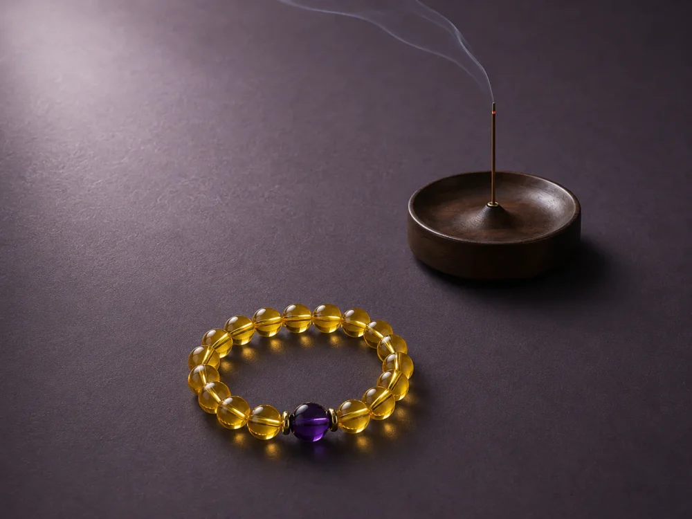 Metal Clarity Clear Citrine Amethyst Bracelet Incense Scene Metal Clarity bracelet with clear citrine beads, purple amethyst center bead, gold-plated spacers, and incense tray