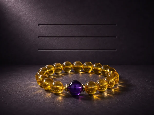 Metal Clarity bracelet with clear citrine beads, purple amethyst center bead, and gold-plated spacers on dark textured background