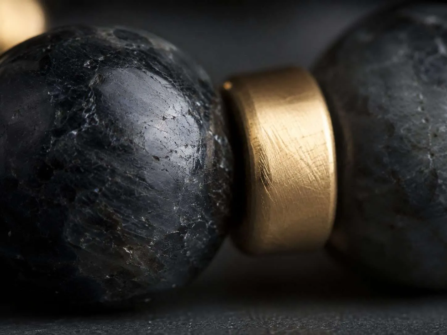 Natural stone, premium obsidian, and metal objects arranged in a calm intentional atmosphere with chiaroscuro still life details