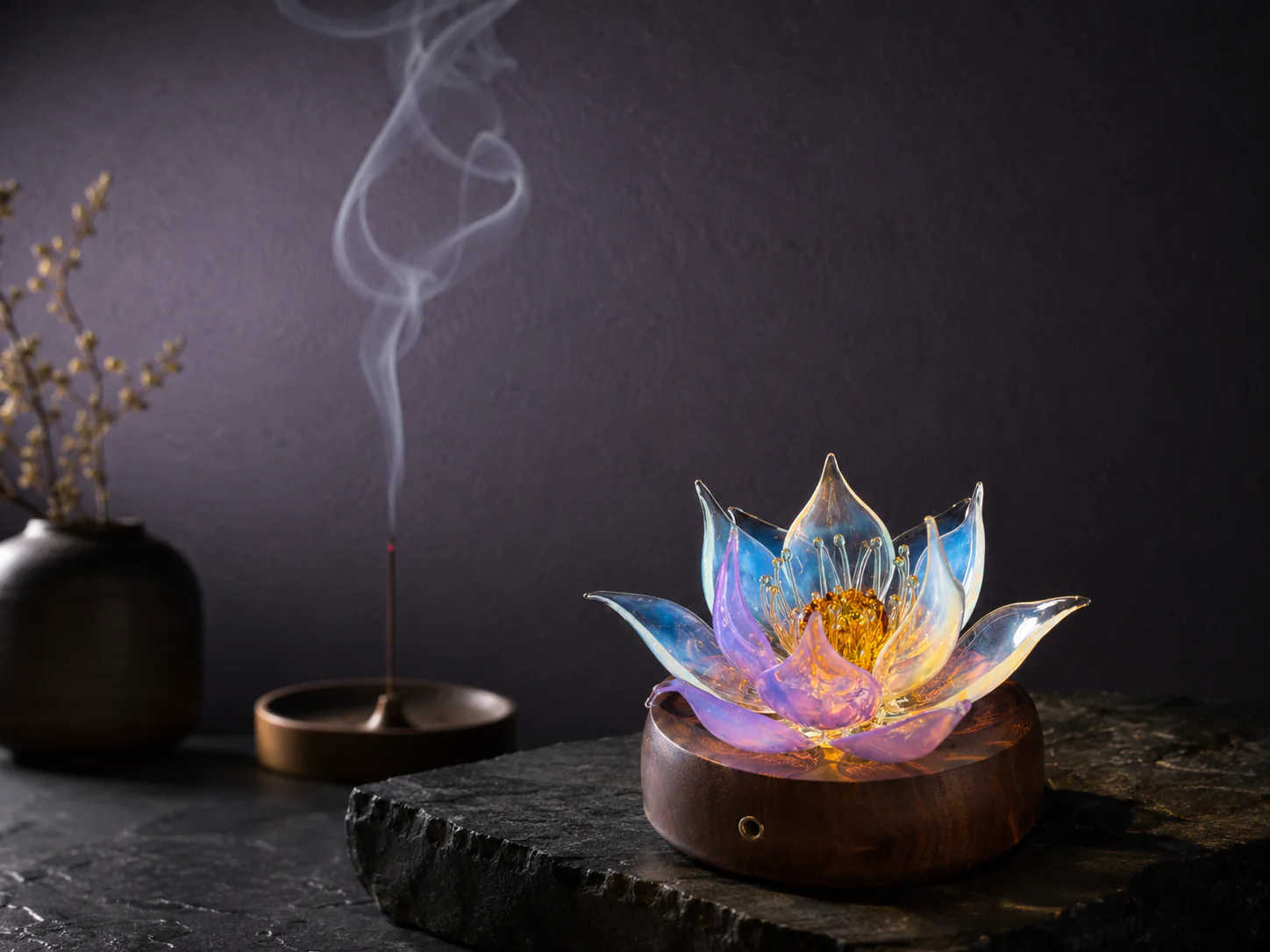 Illuminated 9Purple lampworked glass lotus light showing layered translucent petals on a walnut wood base