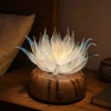 Lunar Lotus Night Glow Glass Lotus Light Lunar Lotus frosted glass lotus light glowing at night on a warm walnut wood base