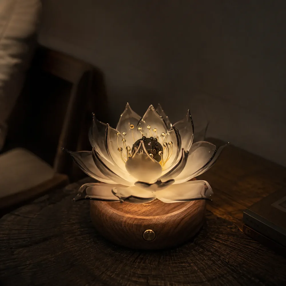 Noir Lotus Night Glow Glass Lotus Light Noir Lotus smoky glass lotus light glowing at night on a warm walnut wood base in a darker room