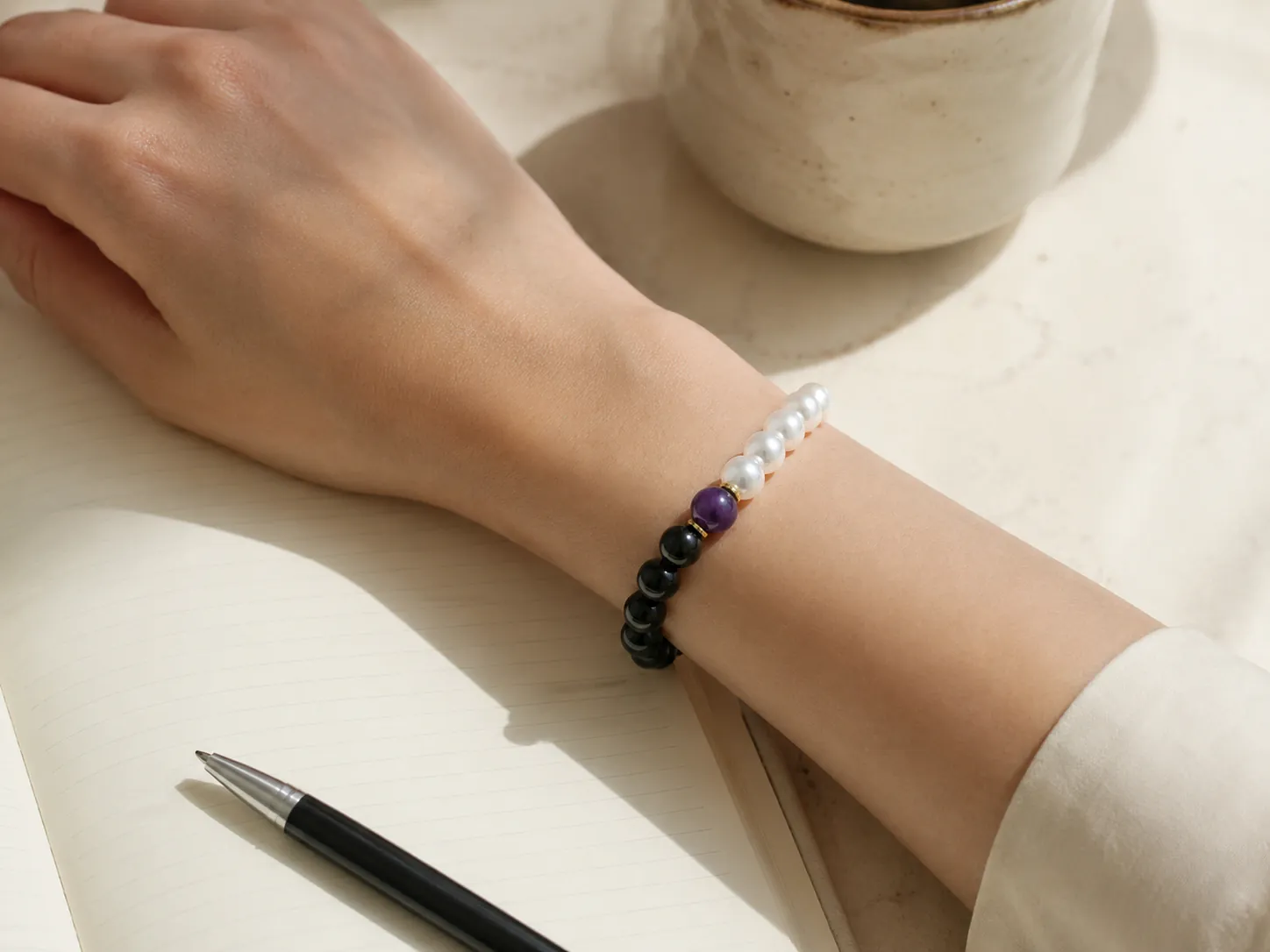Yin yang gemstone bracelet styled beautifully on a wrist with premium neutral clothing textures