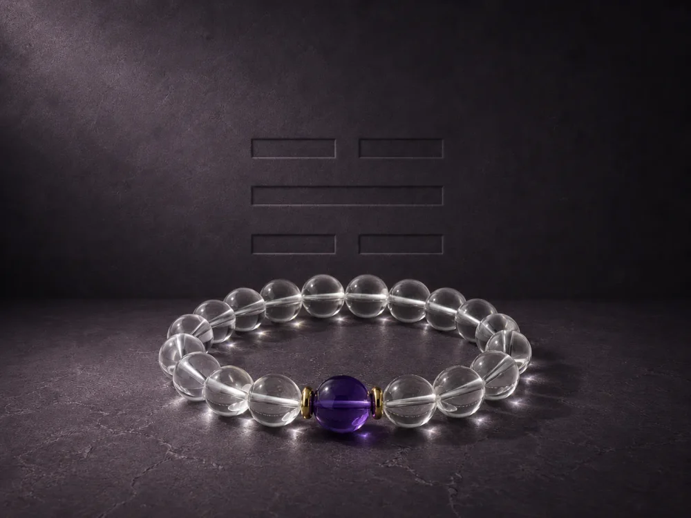 Water Flow bracelet with clear quartz beads, purple amethyst center bead, and gold-plated spacers on dark textured background