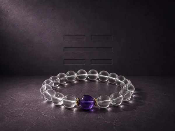 Water Flow Clear Quartz Amethyst Bracelet Hero Image Water Flow bracelet with clear quartz beads, purple amethyst center bead, and gold-plated spacers on dark textured background