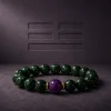 Wood Renewal Ganqing Jade Amethyst Bracelet Hero Image Wood Renewal bracelet with Ganqing jade beads, purple amethyst center bead, and gold-plated spacers on dark textured background