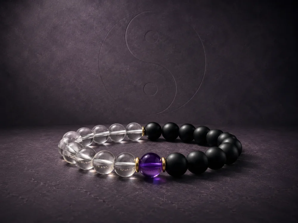 9Purple Yin-Yang Balance single-strand bracelet featuring matte black obsidian, clear white crystal beads, and a central purple amethyst on a dark slate background.