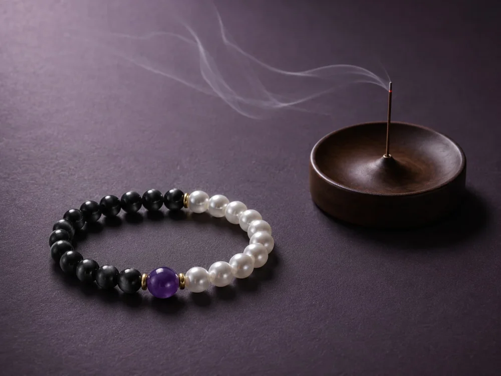 9Purple protective talisman bracelet resting next to a modern bronze incense burner with ethereal smoke.