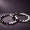 Two 9Purple Yin-Yang luxury protection bracelets displayed together on a premium dark textured surface.