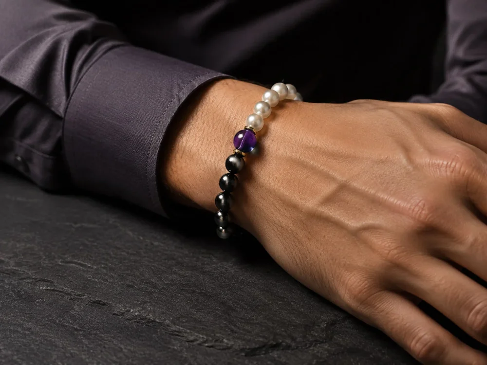 Sophisticated gentleman wearing the 9Purple gold-detailed Yin-Yang obsidian bracelet on wrist with a dark luxury shirt.